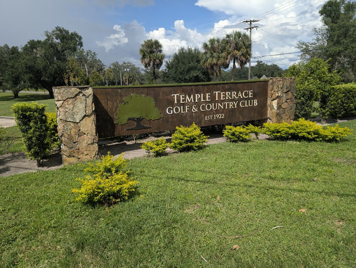The entrance monument of Temple Terrace Golf and Country Club, with its oak-tree emblem, seen from the road.